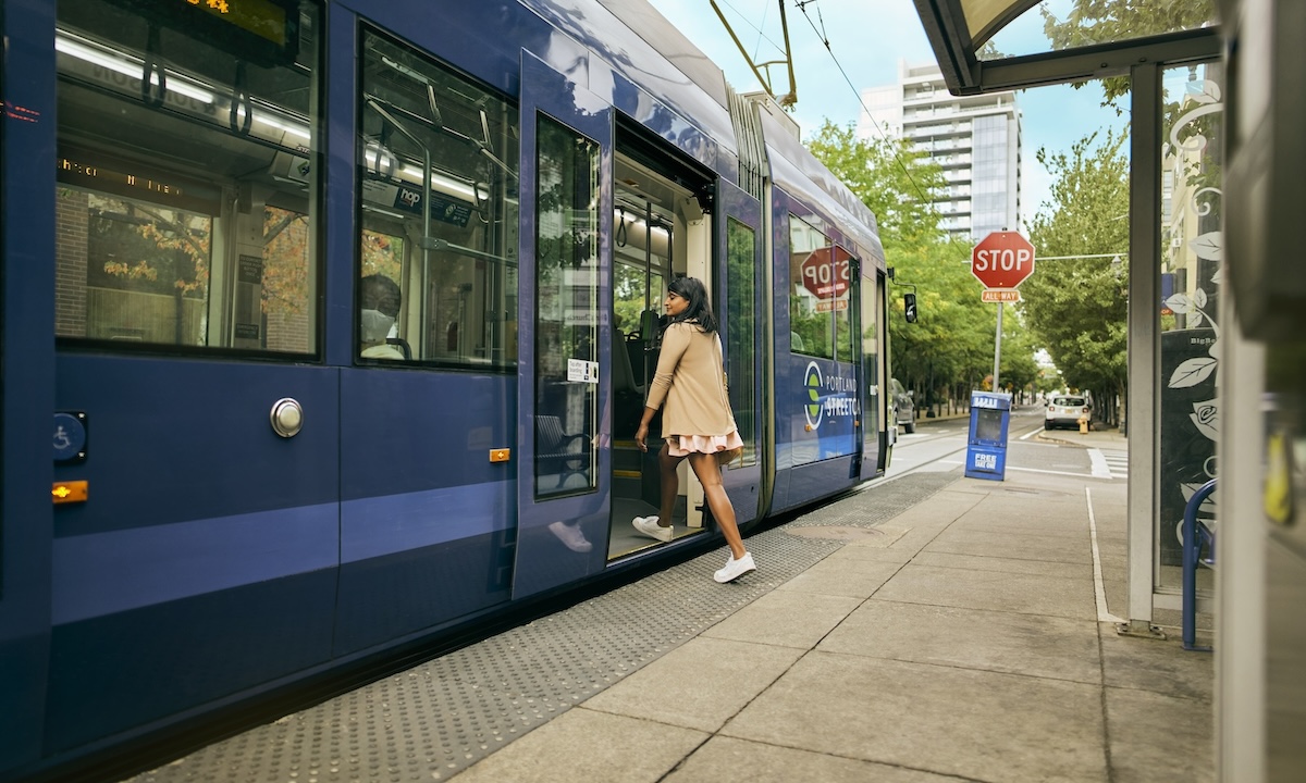 A woman steps onto the Portland Streetcar